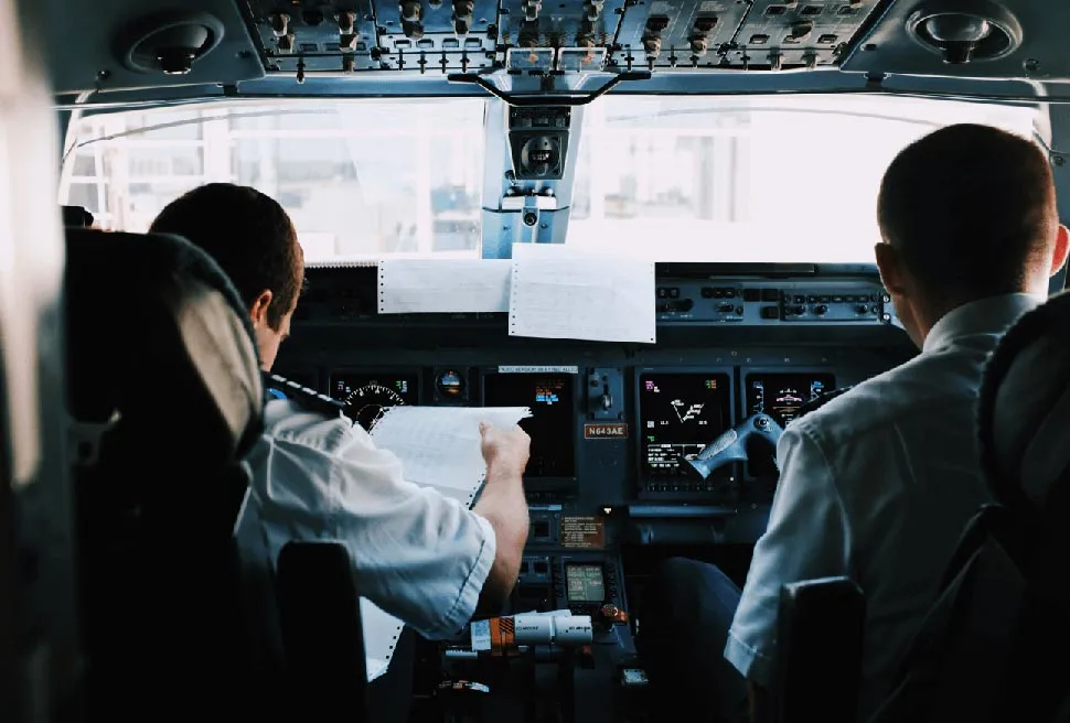 Two pilots sitting in the cabin of the plane